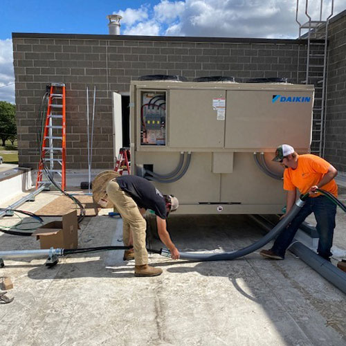 Technicians working on HVAC unit